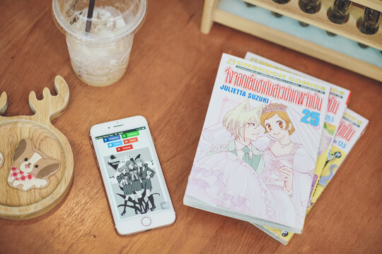 BKK - Jun 21, 2020:  online comic on iPhone8. Concept of transformation from offline to online printing industry and disruption of Japanese manga business. Thai words mean Kamisama kiss, name of manga