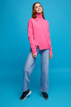 Fashion Portrait Of Young Woman In Pink Sweater And Blue Jeans.