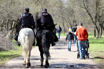 Mounted police patrol the park in spring Moscow. Two russian police officers on horseback