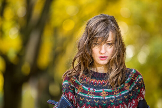 Autumn sadness concept. Woman walking in autumn park