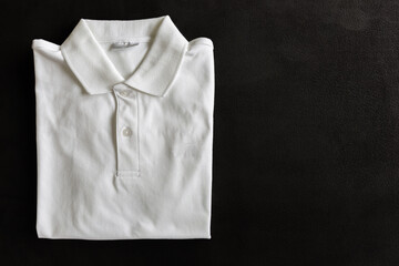 New white Polo Shirt on dark deerskin background in top view