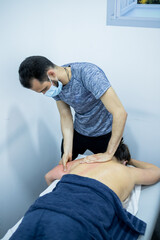 Young man giving medical treatment by ostheopaty. Young man practicing chinese medicine on a patient