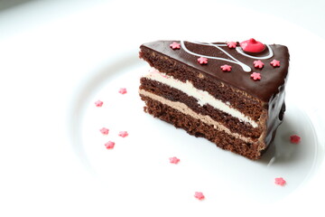 Piece of chocolate cake decorated with pink sugar sprinkles 