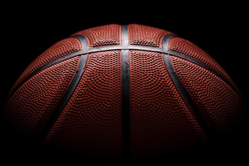 Backdrop textured basketball ball close-up on dark backdrop with dramatic light.