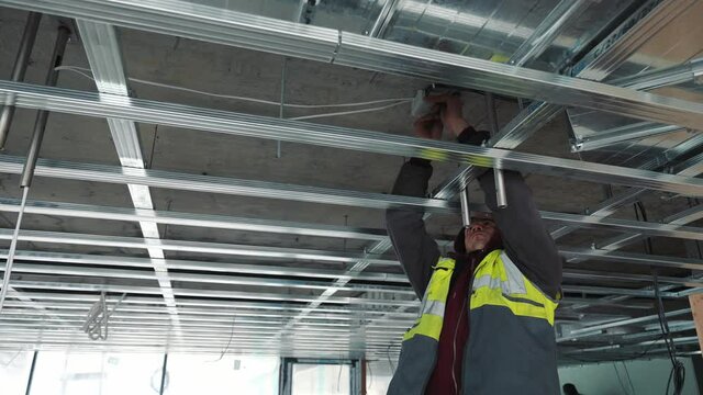 Installation of a ceiling on construction. Renovation in the middle of the house. Creation of a skeleton of networks from metal designs