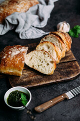 Homemade Ciabatta Bread. Sliced ​​bread slices on a wooden board. Bread with pesto sauce