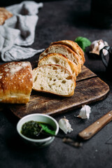 Homemade Ciabatta Bread. Sliced ​​bread slices on a wooden board. Bread with pesto sauce