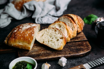 Homemade Ciabatta Bread. Sliced ​​bread slices on a wooden board. Bread with pesto sauce