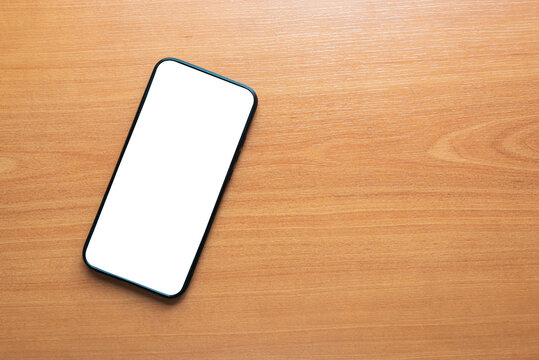 with white screen on a wooden background
smart cell phone.
tectology concept.
white screen for mackup app