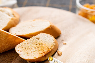 Bread and butter for homemade breakfast with coffee tea milk and organic slide whole wheat rye grain flour brown French  baguette with bio marmalade jam mix with orange passion fruit apricot
