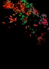 暗闇に飛び散るオレンジと緑の幻想的なテクスチャ背景