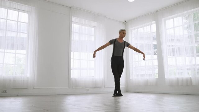 young Asian ballet dancer practicing in a room alone.
