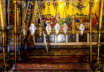 the stone of anointing (unction) greets the visitors, who kneel, pray and kiss the stone. Above the stone are lamps, each donated by one of the denominations.