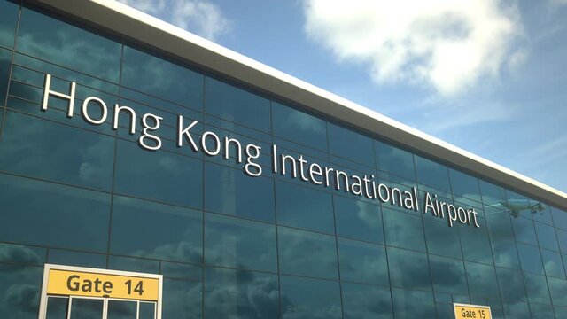 Taking off airplane reflecting in the modern windows with Hong Kong International Airport text
