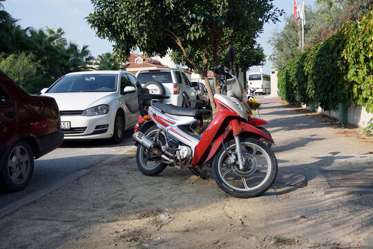 Side / Turkey - October 17 2019: Tricycle and motorcycle are standing near the road waiting for the owners. Convenient and inexpensive transport for moving around the city in warm summer weather.