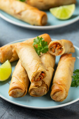 Fried spring rolls with sweet chili sauce and lime on plate
