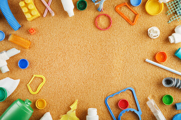 Garbage made of colorful plastic on an oceanic sandy beach.