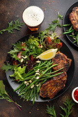 Grilled pork loin chops served with French green beans salad and beer
