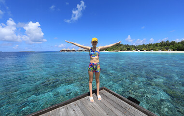 Naklejka premium teenage girl in a swimsuit on the shore of a tropical island