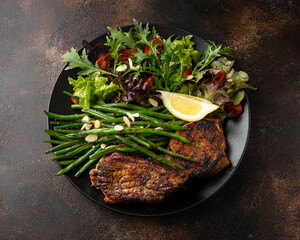 Grilled pork loin chops served with French green beans salad and beer