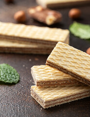 Tasty wafer biscuits with chocolate on rustic table