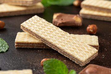 Tasty wafer biscuits with chocolate on rustic table