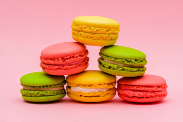 Fototapeta na wymiar pyramid of color macaron cakes on a pink background