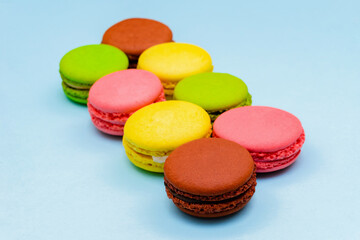 different multicolored macaron cakes on a blue background