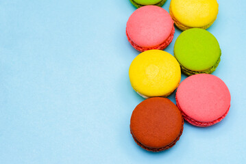 Fototapeta na wymiar different multicolored macaron cakes on a blue background