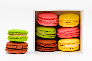 multicolored macaron cakes in a white cardboard box on a white background