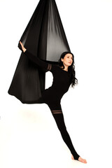 Fly yoga isolated on the white background. Woman doing stretching on black hammock.