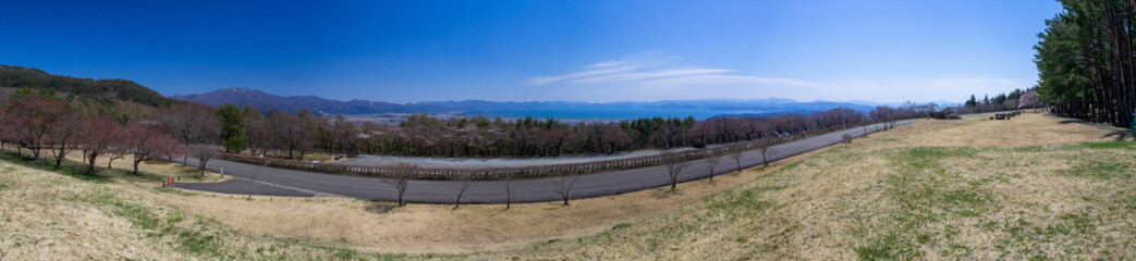 Fototapeta na wymiar Overlooking an early spring forest and huge lake from a lookout in mountain (Inawashiro, Fukushima, Japan)