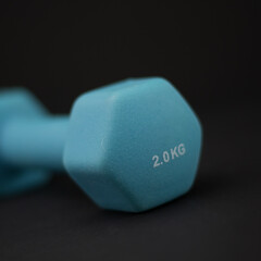 2 kg dumbbells isolated on dark background - home fitness and workout.