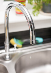 Kitchen tap isolated on bright background. Water saving solutions.