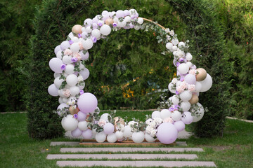 Ouside wedding ceremony. Balloon wedding arch in the garden.