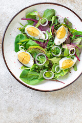 egg vegetables salad green leaves mix spinach, arugula, lettuce on the table wholesome food healthy meal snack copy space food background rustic. top view keto or paleo diet veggie or vegetarian
