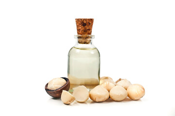 Macadamia nuts heap and macadamia oil in glass bottle isolated on a white background.