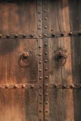 Retro lion head iron door knocker on ancient Chinese wooden door