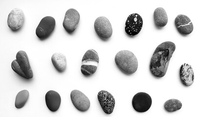 Collection of black and white stones of sea pebbles on a white background.  Pattern, monochrome, Top view, flat lay.