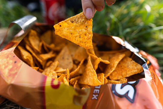 Close Up Photo Of A Nacho Being Picked By A Female In A Park