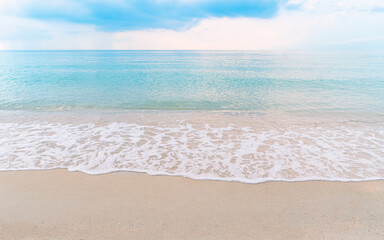 Beautiful paradise beachscape, turquoise color water, wave with white bubbles, blue sky with light in the morning, clean beach, reflection of sunlight in surface of sea, no people, wide image.