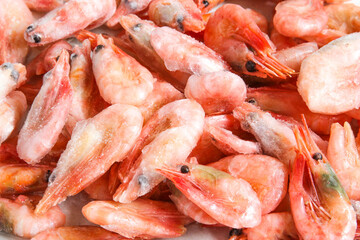 Close-up of a pile of frozen shrimps. No cleaned shrimp. Seafood background.