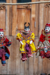 Colorful puppets in a tourist stall on the street market in Burma, Myanmar. Handmade dolls hanging...