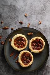  top view pecan tarts on a grey plate