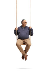 Smiling mature man sitting on a wooden swing and looking to the side