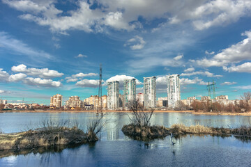 Obraz premium A wide blue lake and high-rise buildings. Lake and residential area on the other side