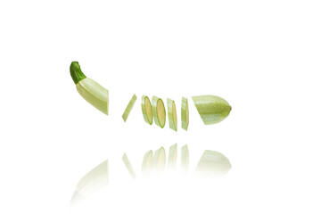 One vegetable marrow fresh sliced many small slices isolated on white floats freely in the air.  Concept levitation food.