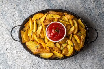Roasted potato wedges with herbs and sea salt on plate, top view (Turkish name; elma dilim patates)