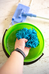 Washing a doormat in a bucket of water. Room cleaning.
