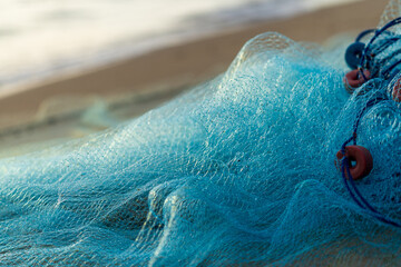 Blue fishing net on a beach sand  in the sunrise time.